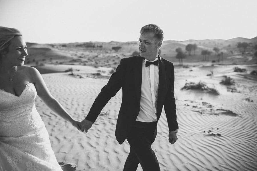 Bräutigam Hand in Hand mit Braut in der Wüste